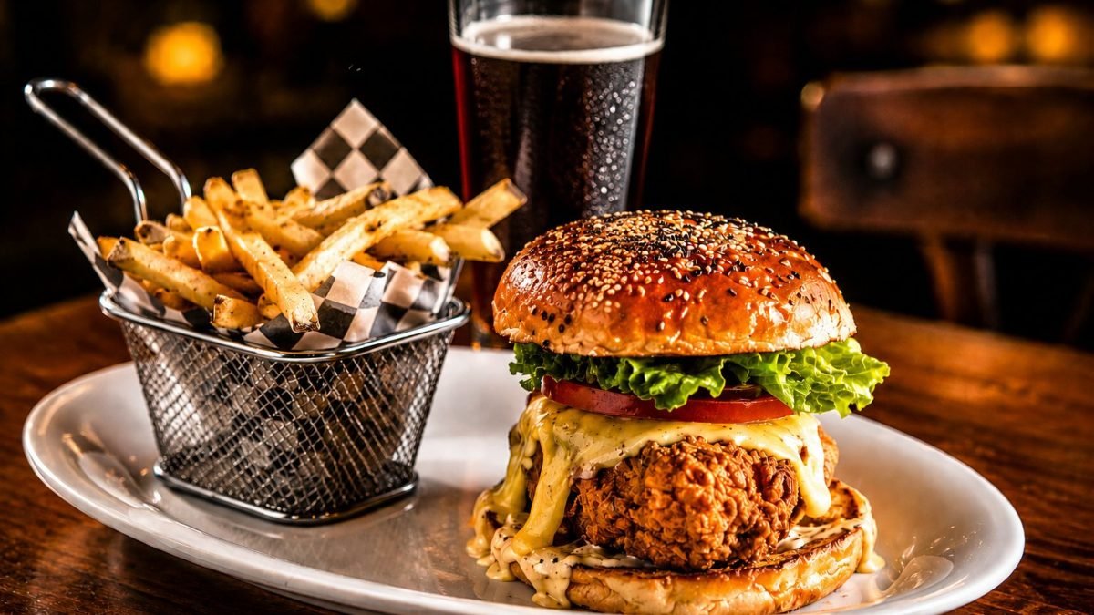 Hamburguesa de pollo con papas servida en un sports bar en Nuevo Vallarta